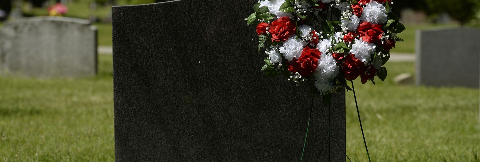 red and white wreath beside a monument