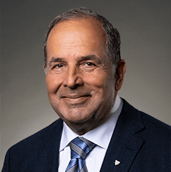 balding man smiling wearing a suit and tie