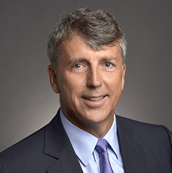 smiling man with grey hair and a suit