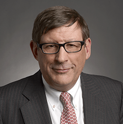 man with brown hair and glasses and a suit and tie